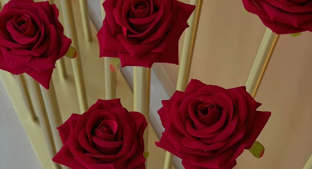 Detail of red roses raised on gilded rods.